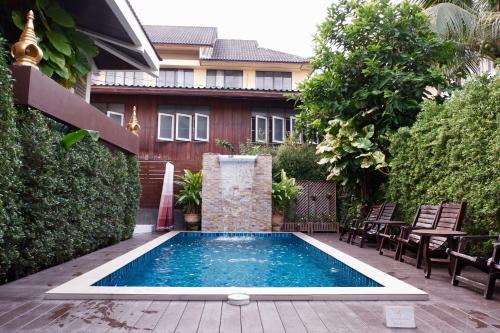 清迈埃兰纳经济型酒店的一座房子后院的游泳池
