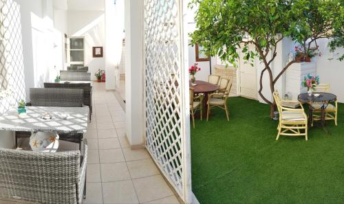 奥尔比亚Zia Mia B&b的一间设有绿色地板和桌椅的客房
