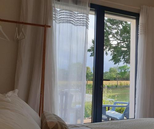 圣佩尔港Le Grand Jardin的一间卧室设有一张床和一个大窗户