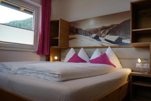弗拉绍Bergfink apartments的一间卧室配有带粉色和白色枕头的床
