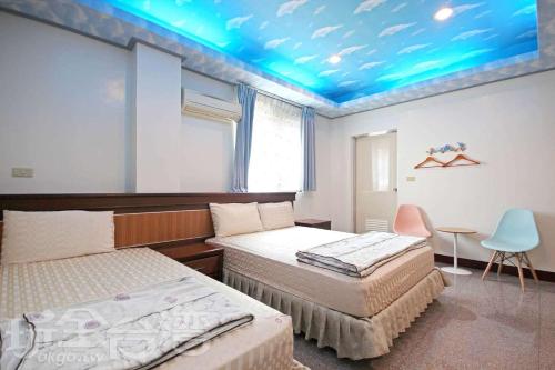 集集镇集集苹果的家民宿的一间卧室设有两张床和蓝色的天花板