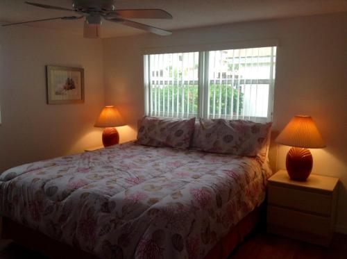 Point O'RocksIsland House Beach Resort 21的一间卧室配有一张带两盏灯的床和一扇窗户。