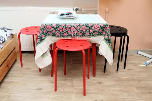 日拉尔杜夫Tanie Noclegi Mieszkanka的一张桌子,上面有两把红色凳子,上面有布