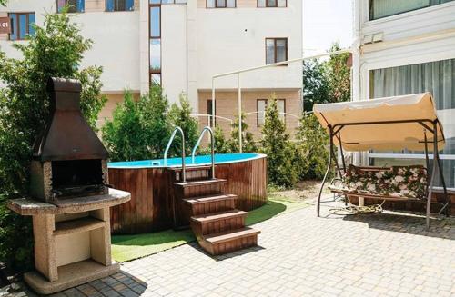 敖德萨乔治格拉德公寓的一个带烧烤架和游泳池的后院