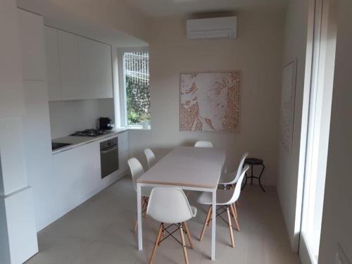 韦内雷港Olivo House 2的白色的厨房配有桌子和白色椅子
