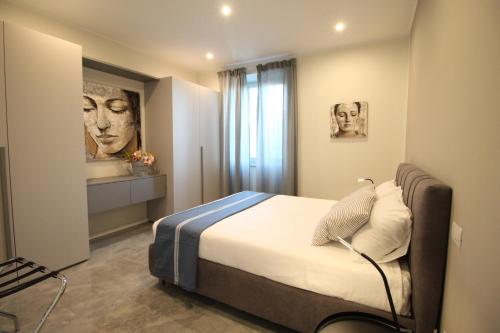 阿拉西奥Casa Vacanze Residence Ideale Suites and Apartments的卧室配有一张床,墙上挂有绘画作品