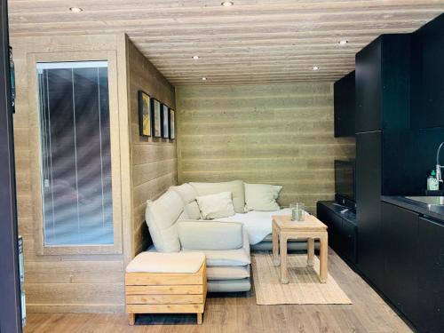 圣埃蒂安德蒂内埃duplex en plein centre d'Auron déco chalet cosy的带沙发和桌子的小客厅