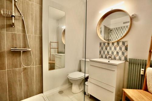 多维尔Studio Royal de la Plage的一间带卫生间、水槽和镜子的浴室
