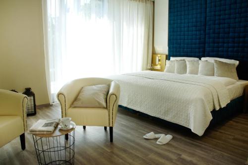克尔斯特尔巴赫Hotel Athen Kelsterbach Frankfurt Airport的卧室配有一张白色大床和一把椅子