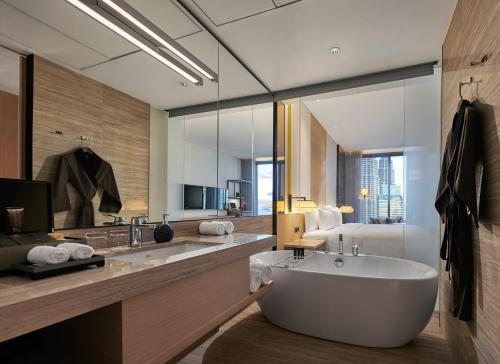 吉隆坡EQ Kuala Lumpur的一间带大浴缸的浴室和一间卧室