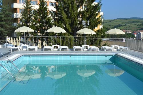 乔阿久拜杰米萨拉酒店的一个带椅子和遮阳伞的游泳池