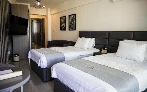 拉纳卡Jimmy's Suites的酒店客房设有两张床和一台平面电视。
