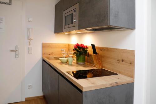 萨尔茨堡Apartments Ante Portas的厨房配有水槽和鲜花台面