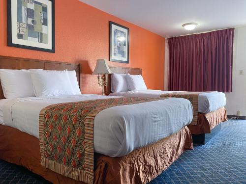 列治文山Royal Inn Richmond Hill- Savannah I-95的橙色墙壁的酒店客房内的两张床