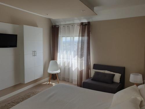里瓦德奥Apartamento centro Ribadeo的卧室配有床、椅子和窗户。