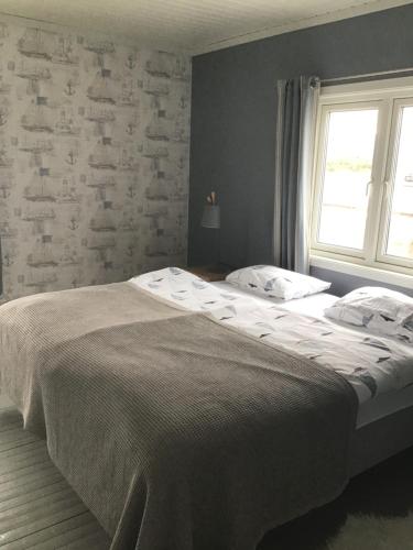 LaukvikLaukvika rorbuer的一间卧室设有一张大床和一个窗户。