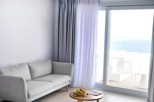 费拉Lilium Hotel Santorini的带沙发和大窗户的客厅