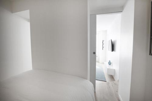 巴黎Stylist and cosy appartement in Montparnasse的一间白色卧室,配有一张床和一个走廊