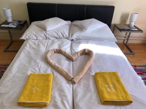 锡盖特堡Hotel Oroszlán Szigetvár的心形床,带两条毛巾