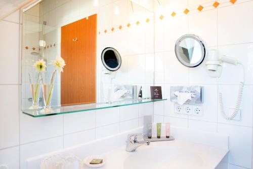朗根阿根斯宜浦尔勒酒店的一间带水槽和镜子的浴室