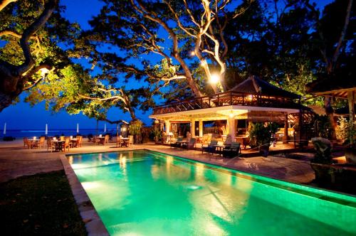 沙努尔丹戎乌萨里酒店的夜间在房子前面的游泳池