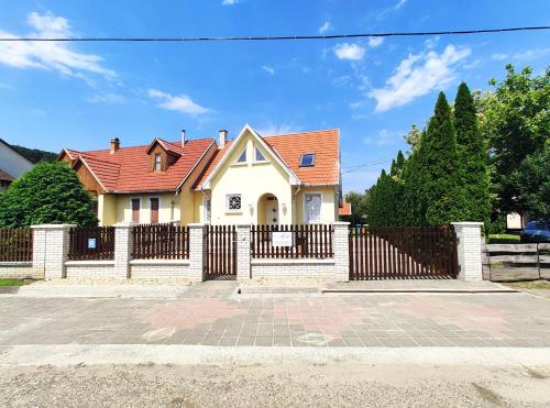 博加奇Apollo Vendégház的白色的房子,有栅栏和门