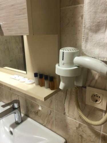 努赛宾Avesis Hotel的一间带水槽的浴室和墙上的一部电话