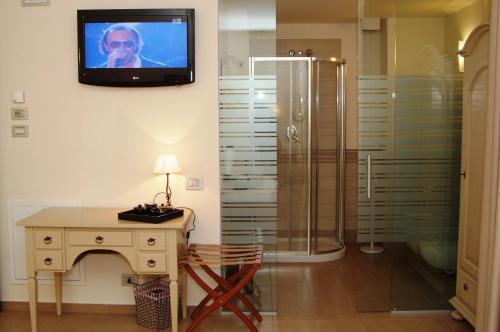 Villongo SantʼAlessandro皮克洛普林西比酒店的带淋浴的浴室和墙上的电视