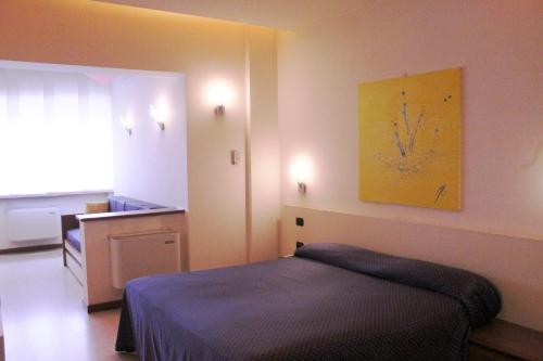 托尔托纳HOTEL OASI的卧室配有一张床,墙上挂着一个钟