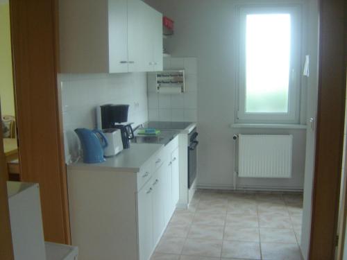 米德尔哈根Ferienwohnung Kathrin Kankel Alt Reddevitz的一间小厨房,配有白色的橱柜和窗户