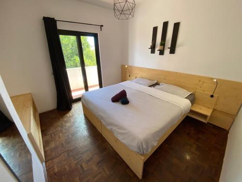 萨格里什Algarve Surf Hostel - Sagres的一间卧室配有一张带木制床头板的床