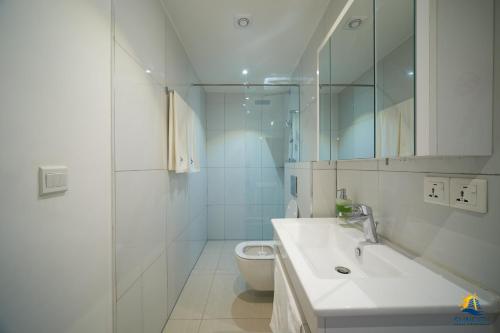 阿克拉Suncity Hotel Apartment的白色的浴室设有水槽和卫生间。