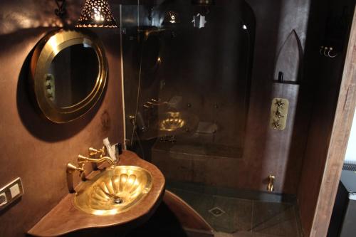 卡塞雷斯波希米亚酒店的一间带金色水槽和淋浴的浴室