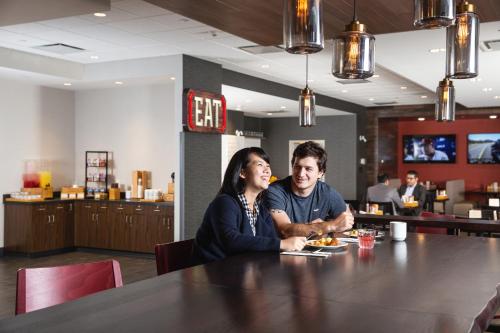 埃德蒙顿Holiday Inn Edmonton South - Evario Events, an IHG Hotel的坐在餐厅桌子上的男女