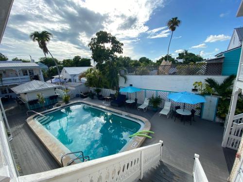 基韦斯特棕榈酒店的一个带桌椅和遮阳伞的甲板上的游泳池