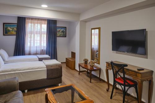 普列文Hotel Splendid的配有一张床和一台平面电视的酒店客房