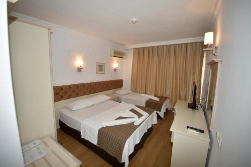 马尔马里斯Almena city的酒店客房设有两张床和电视。