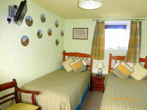 Bainbridge哈泽尔斯鲁斯特住宿加早餐旅馆的一间卧室设有两张床,墙上配有电视。
