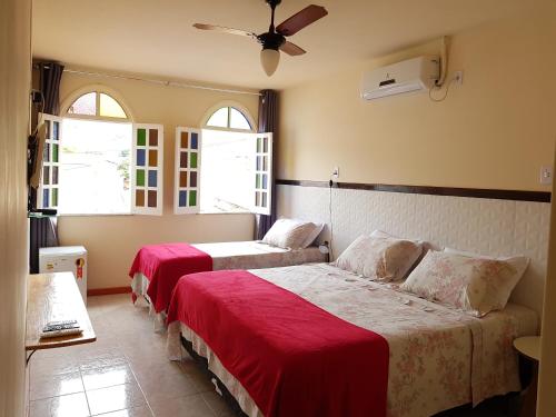 伦索伊斯Pousada da Villa的带2扇窗户的客房内的2张床
