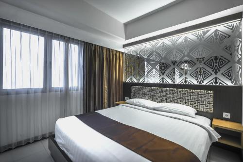 泗水维尔伍德服务公寓及酒店的一间卧室设有一张大床和一面墙