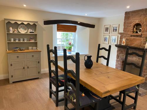 WarcopThe Cosy Nook Cottage Company - Cosy Cottage的一间带木桌的用餐室和一间厨房