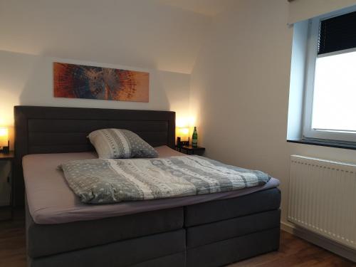 布伦瑞克bs-fewo de - Ferienwohnung Janssen的一间卧室配有一张带床罩的床和窗户