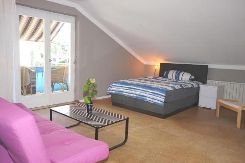 洛豪Haus Bregenz Apartment Bodensee的一间卧室配有一张床、一张沙发和一张桌子