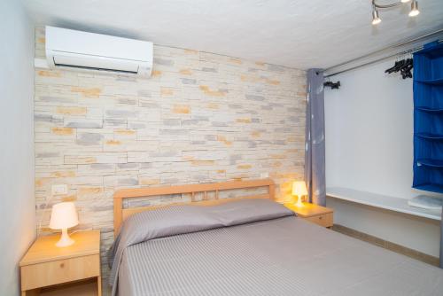 奥尔比亚Appartamento del Cormorano的一间卧室设有一张床和砖墙