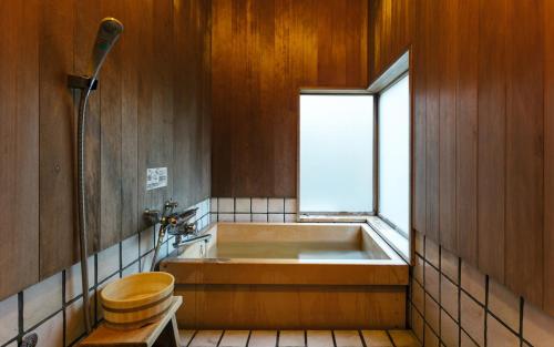 筑紫野市大丸旅馆的带浴缸、卫生间和窗户的浴室