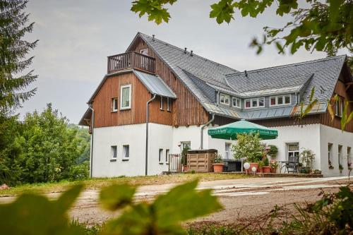 库罗阿尔滕堡Erzgebirgshotel Misnia Bärenfels的白色的大房子,设有木屋顶
