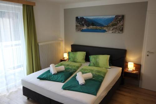 AusserfragantFlattach Apartment 2的一间卧室配有两张带绿色枕头的床