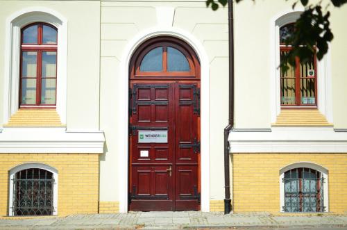 弗罗茨瓦夫翁德酒店及商务中心的白色建筑一侧的红色门