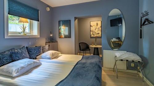 哥德堡Treetop Spa Hangout & Hotel的一间卧室配有一张大床和镜子