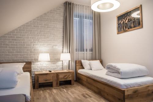 米利奇Hotel Naturum的一间卧室设有两张床和砖墙